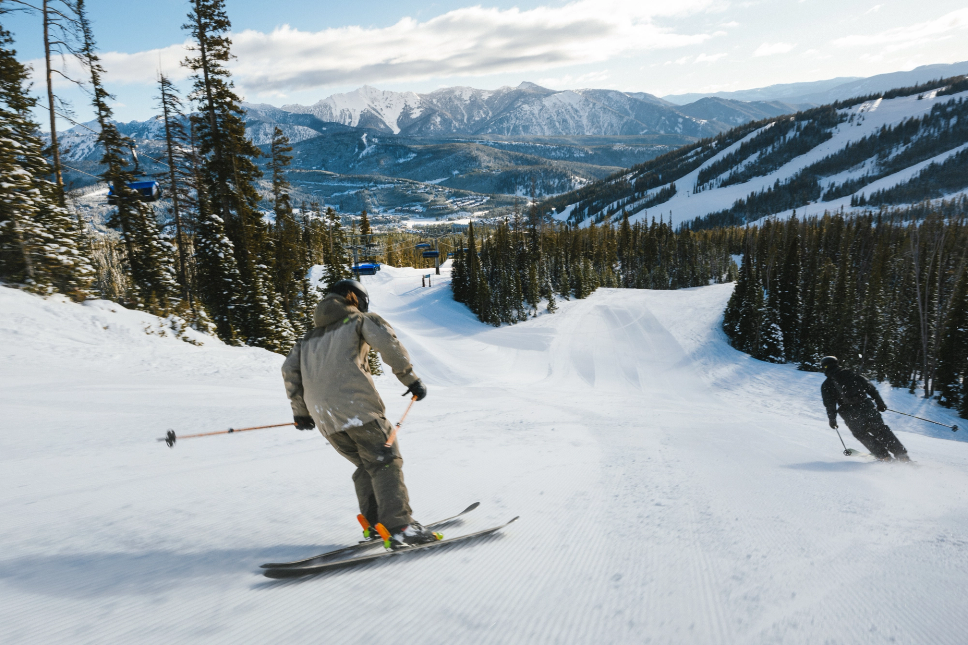 Two skiers on a groomed run