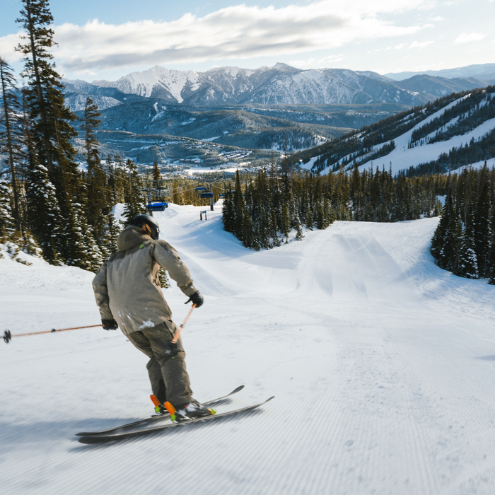 Two skiers on a groomed run