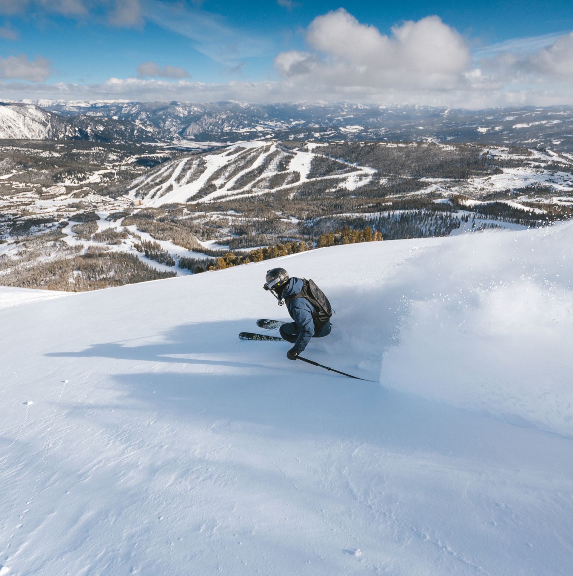 Skier with views of the surrounding mountains at Big Sky Resort