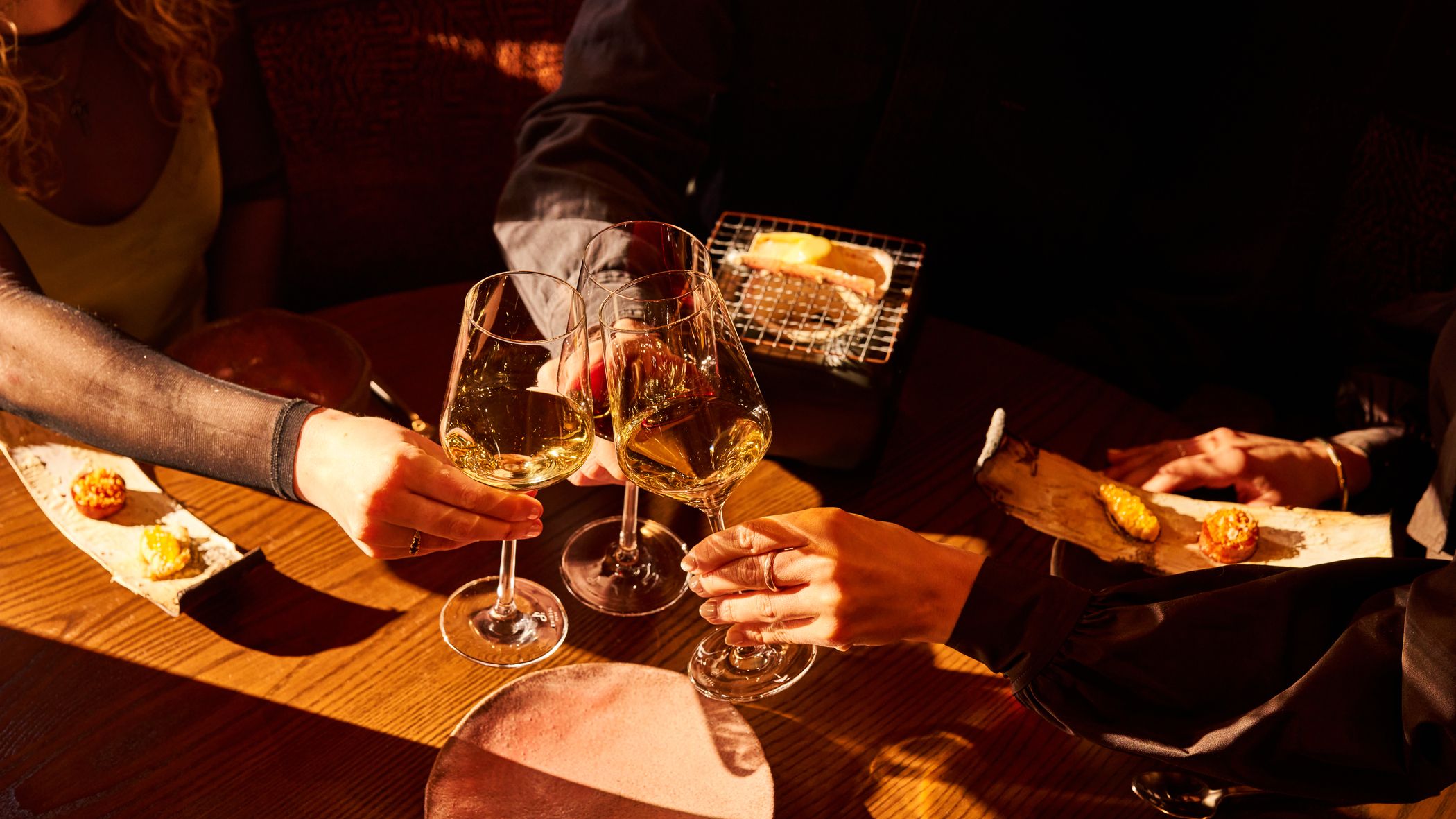 People cheersing drinks at M by The Alinea Group