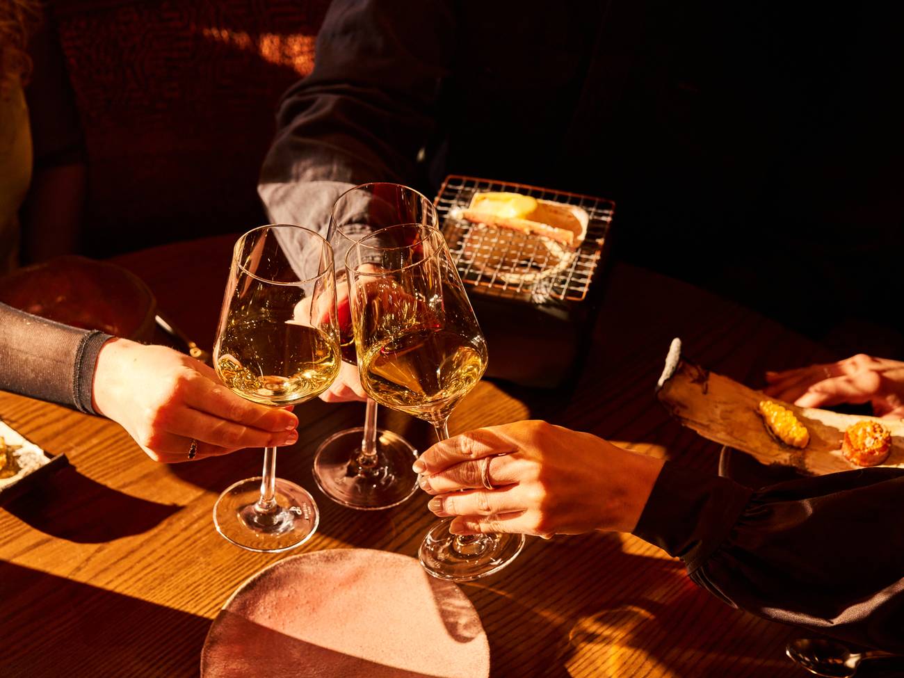 People cheersing drinks at M by The Alinea Group