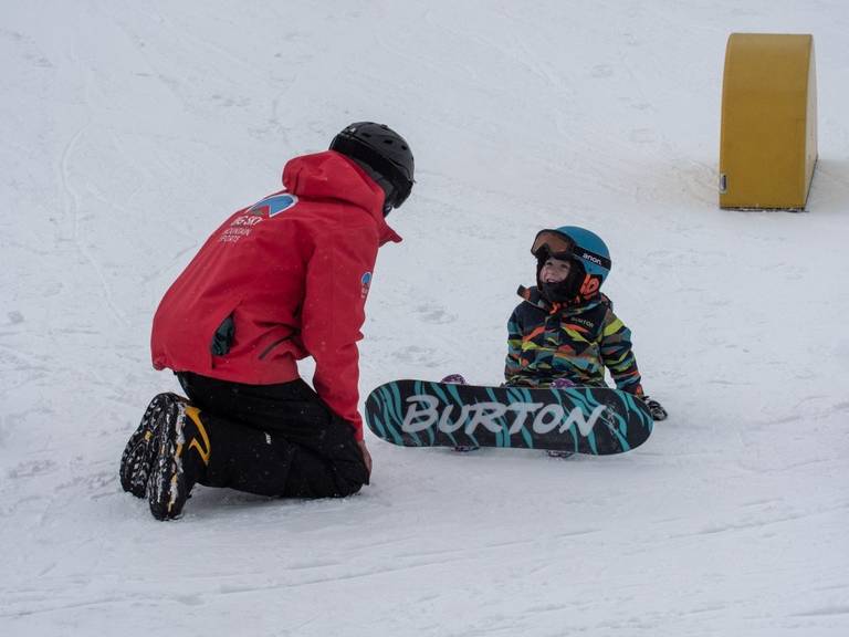 Child and instructor in a snowboard lesson