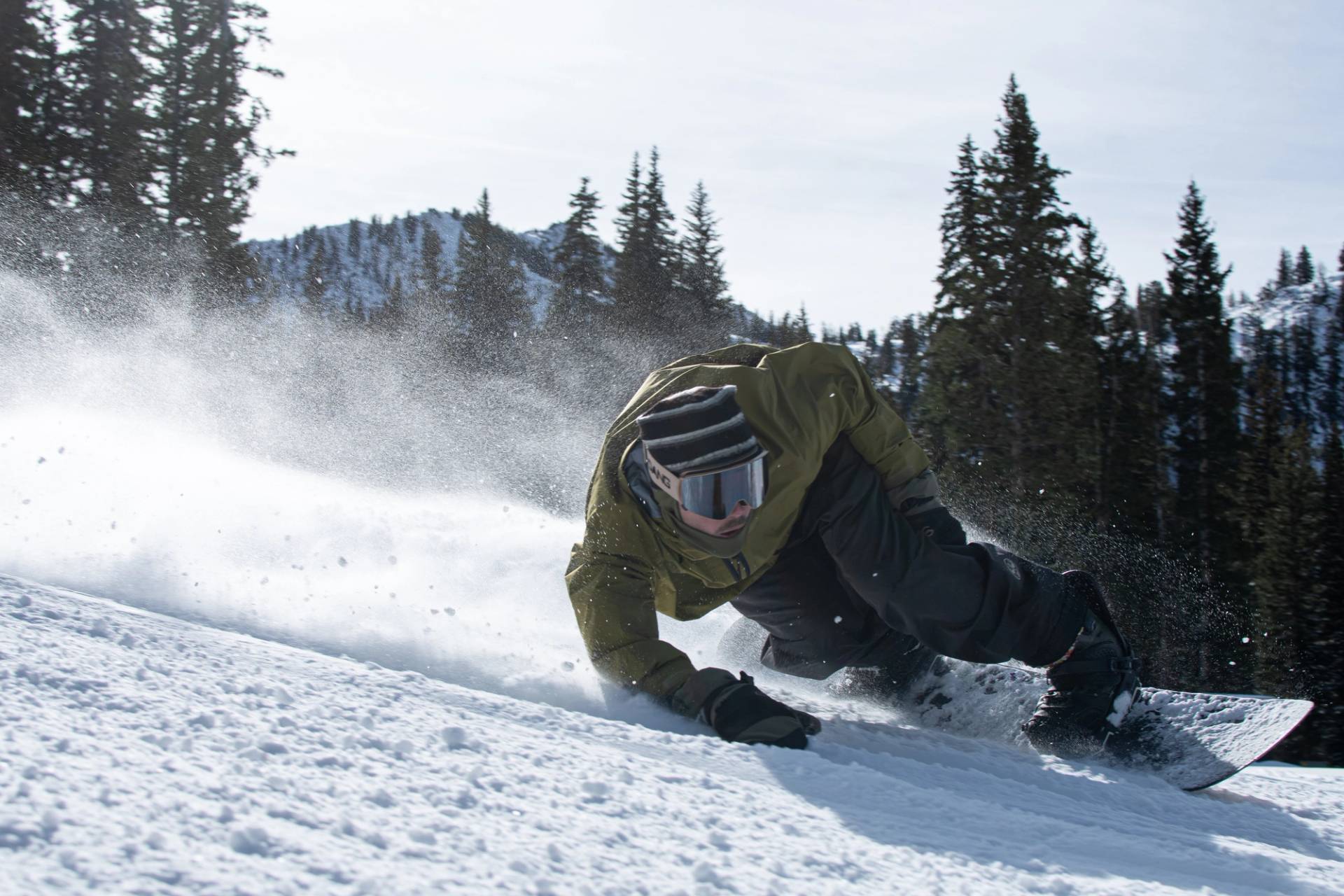 Snowboarder carving a groomer