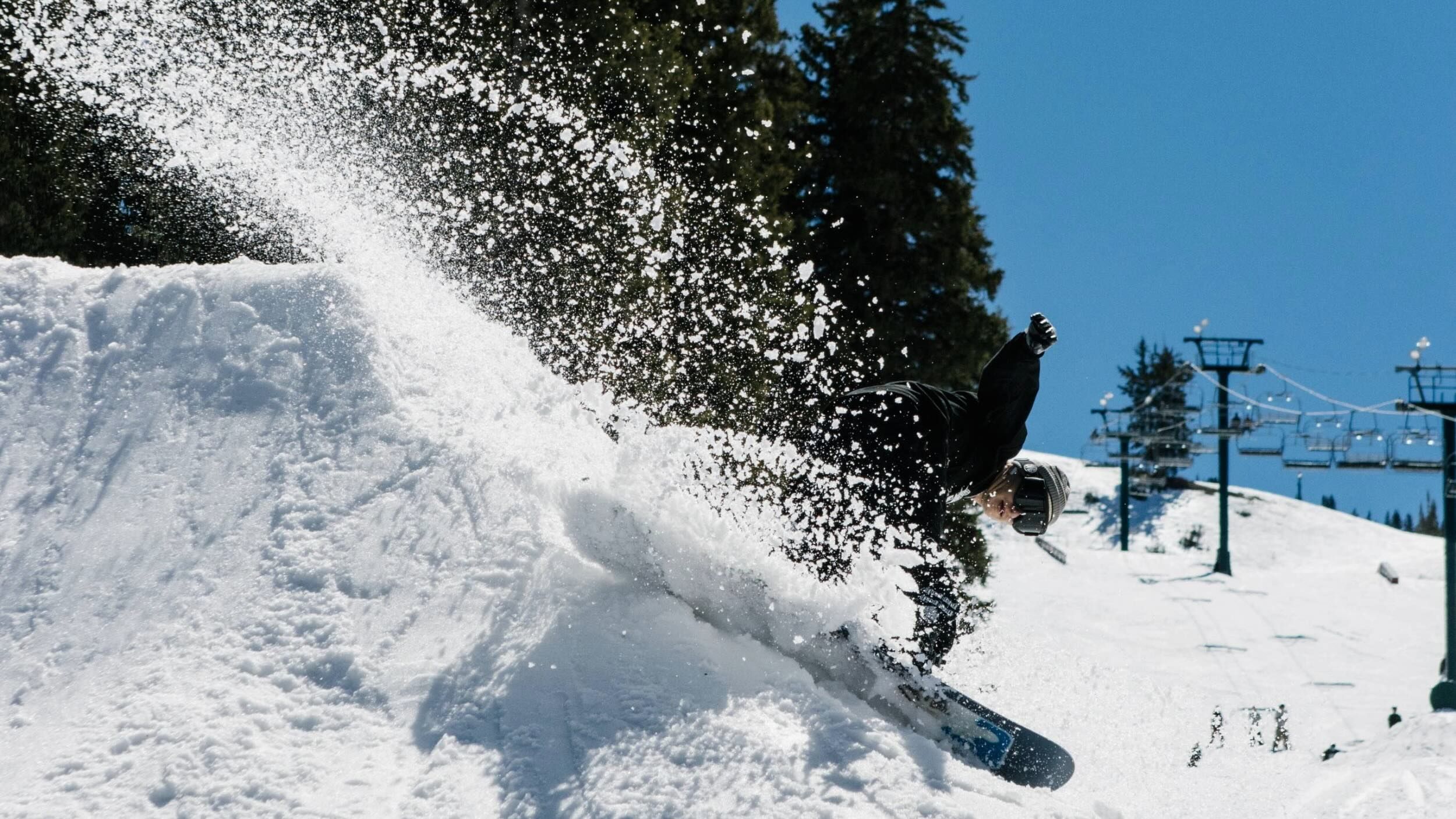 Snowboarder slashing spring slush at Brighton Ski Resort