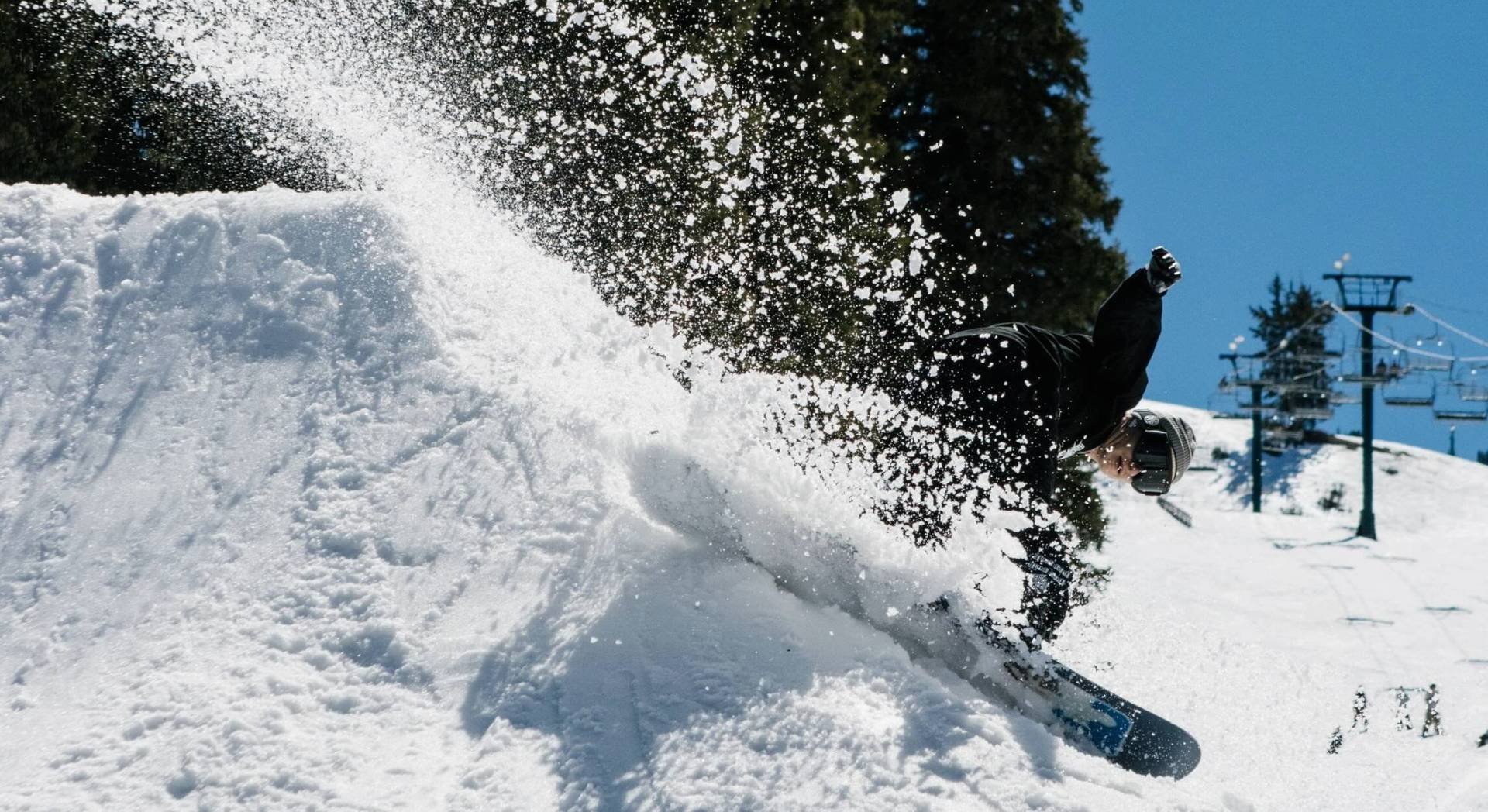 Snowboarder slashing spring slush at Brighton Ski Resort