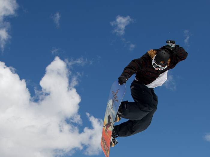 Snowboarder tail grab on a jump during The Meltdown