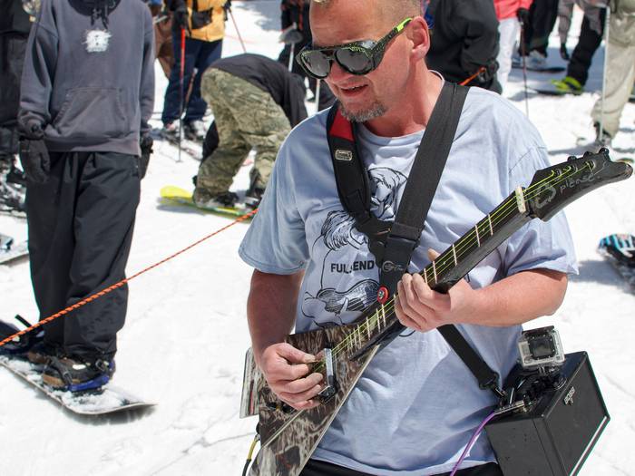 Guy playing guitar on skis