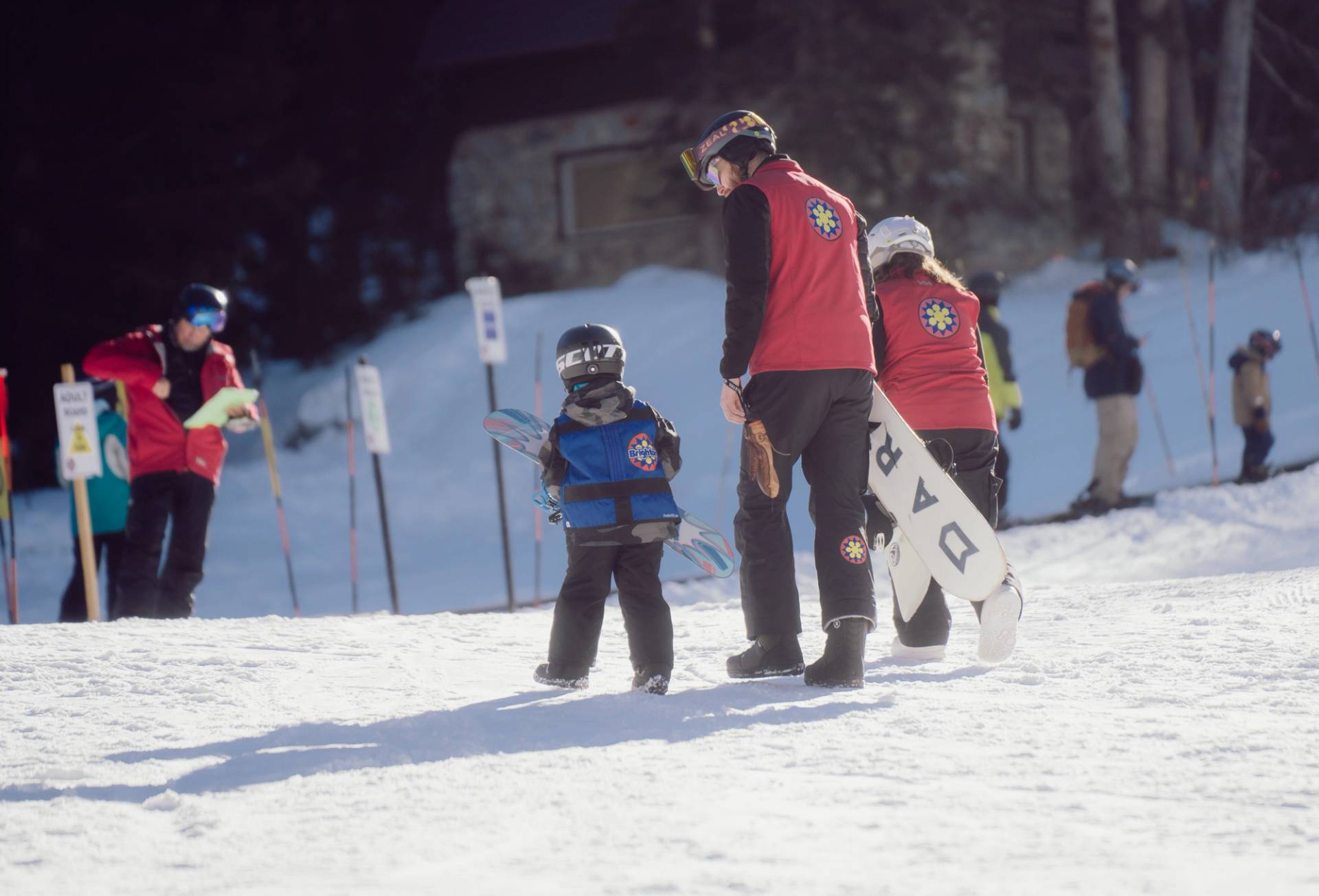 Ski instructor helping kid during lesson