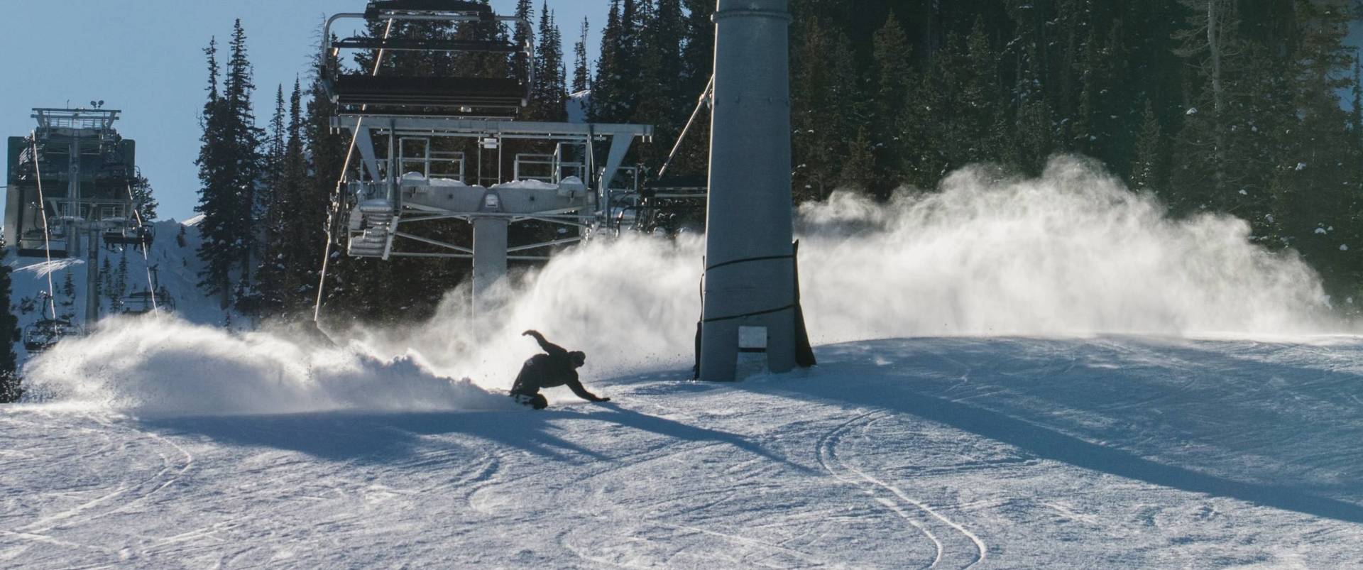 Snowboarder riding down Crest at Brighton Ski Resort