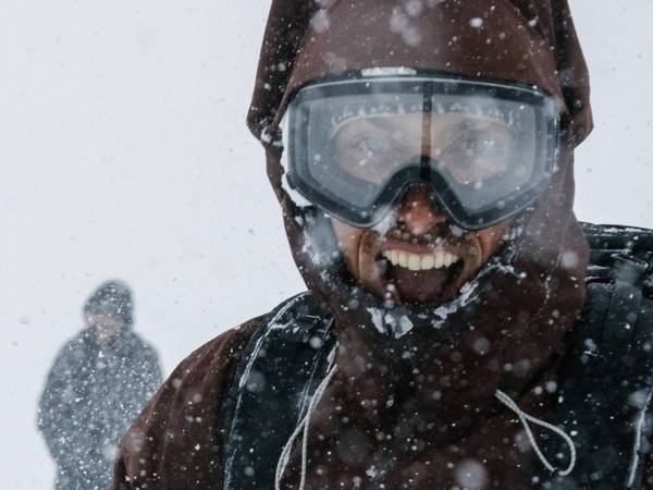 Snowboarder and skier smiling in snow at Brighton Resort