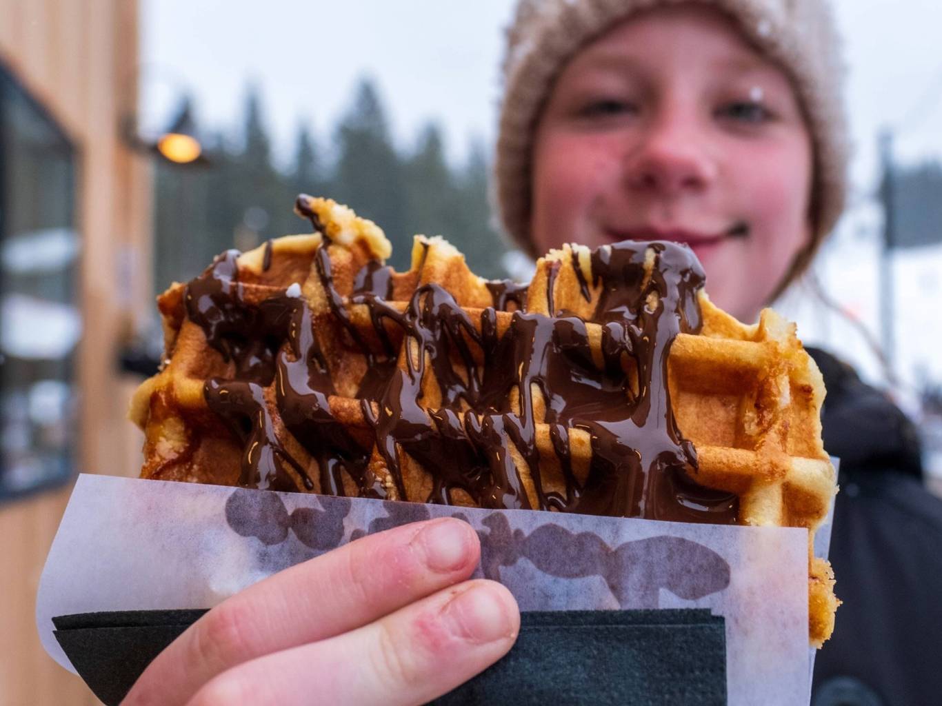 Kid with chocolate covered waffle from the Waffle Cabin at Brighton Resort
