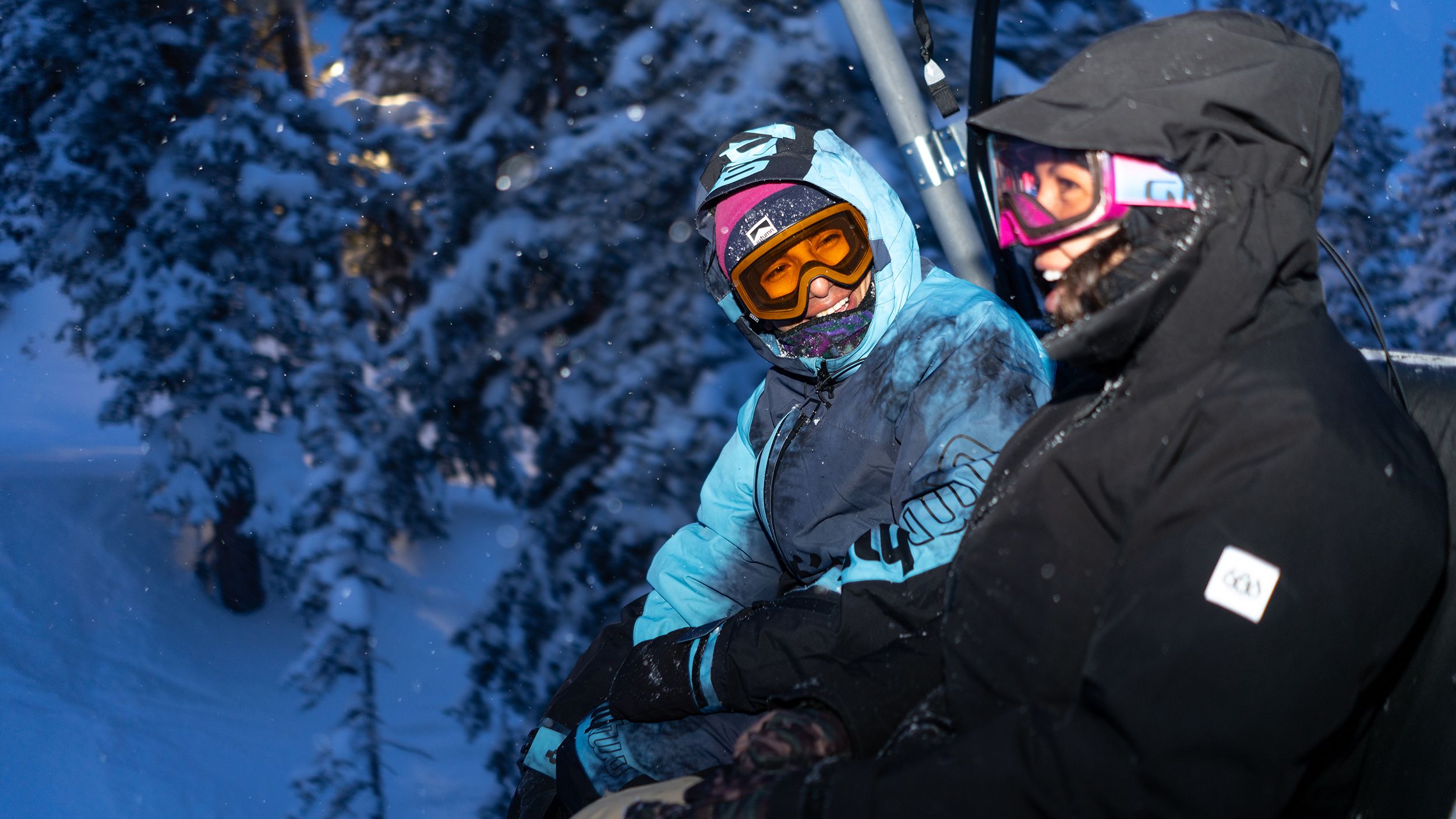 Friends on chair lift night riding