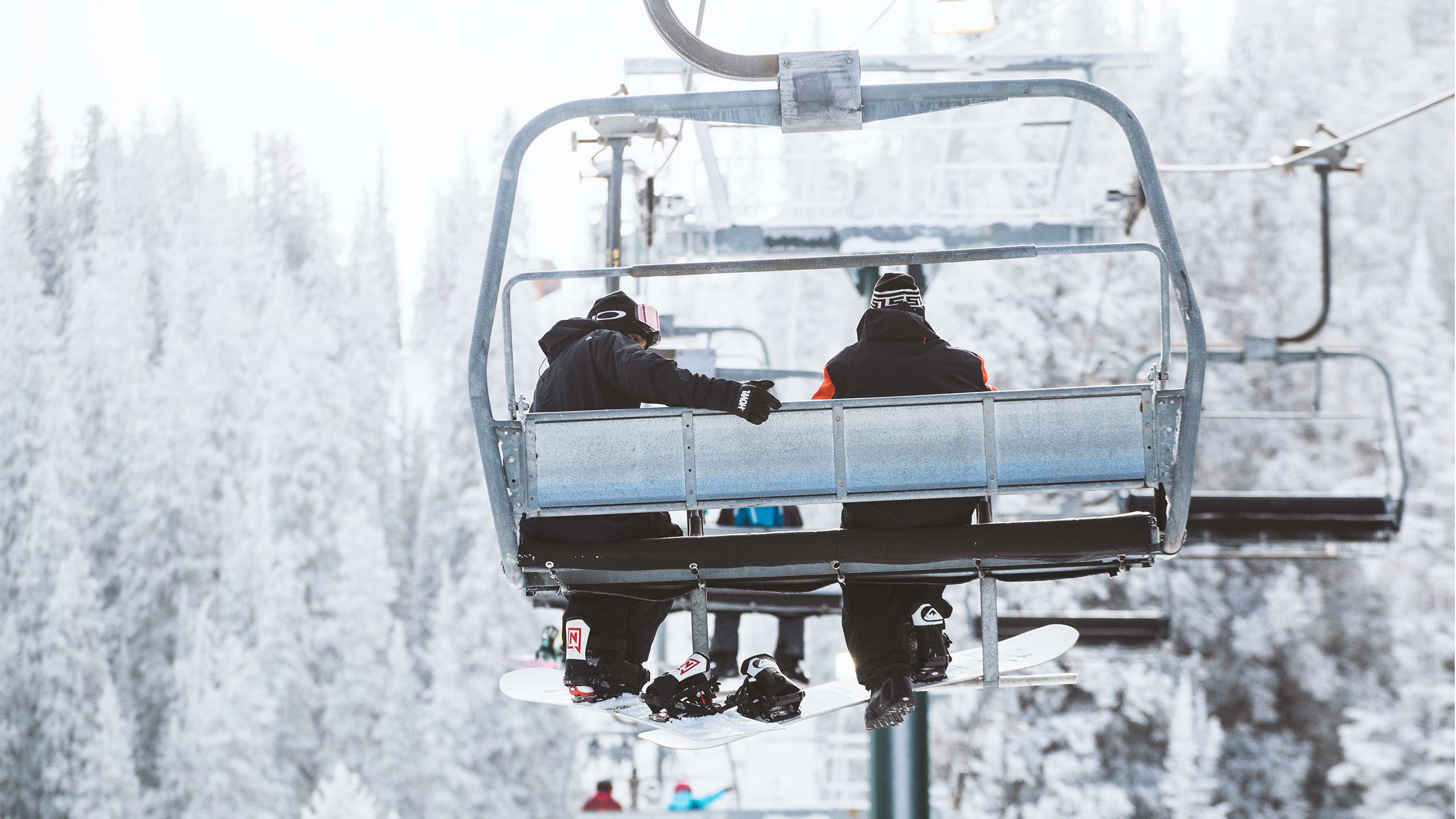 Snowboarders on a chairlift at Brighton Resort