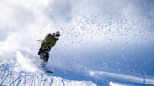 Snowboarder riding through deep powder at Brighton Resort | Brighton Resort Winter Season Pass
