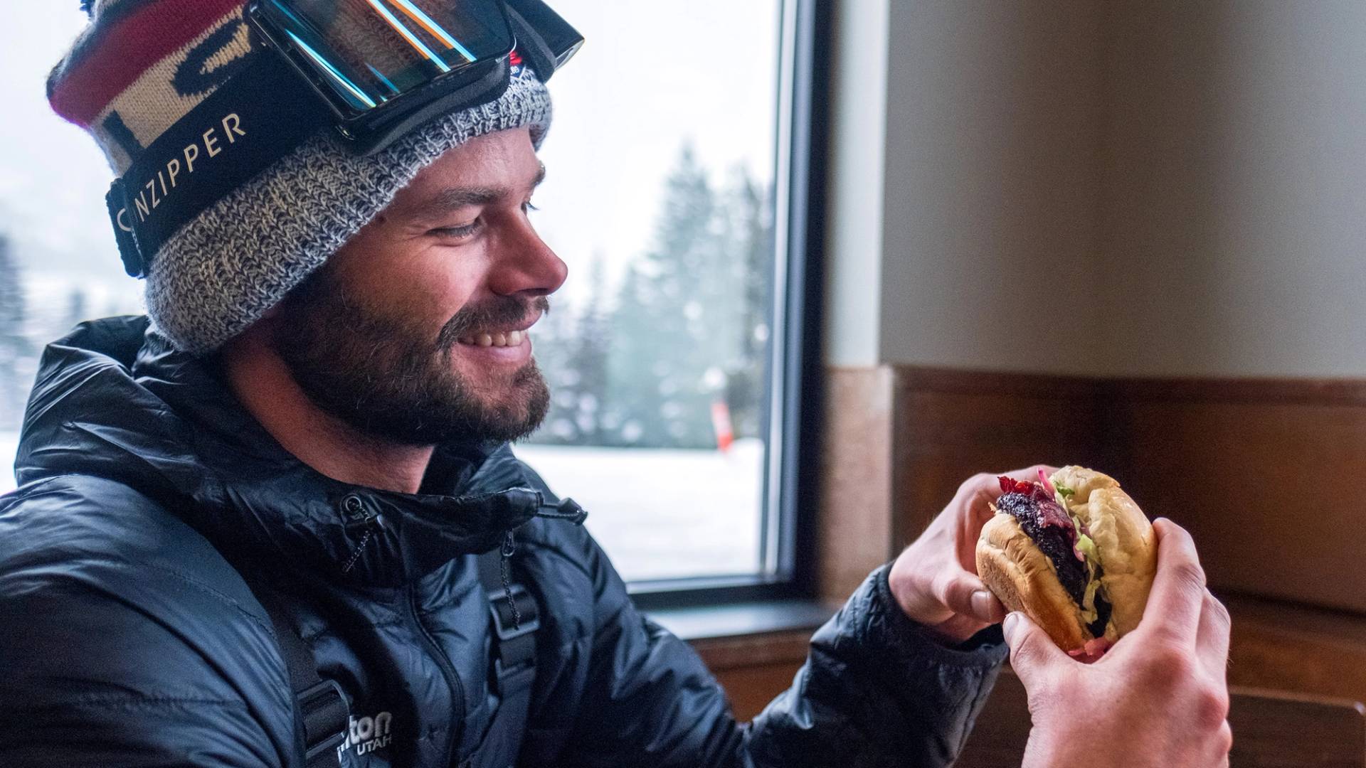 Skier eating a burger in the Sidewinder at Brighton Resort