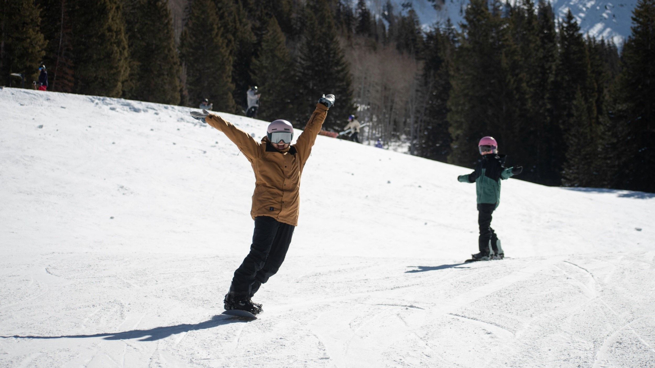 Friends snowboarding together by Snake Creek at Brighton Resort