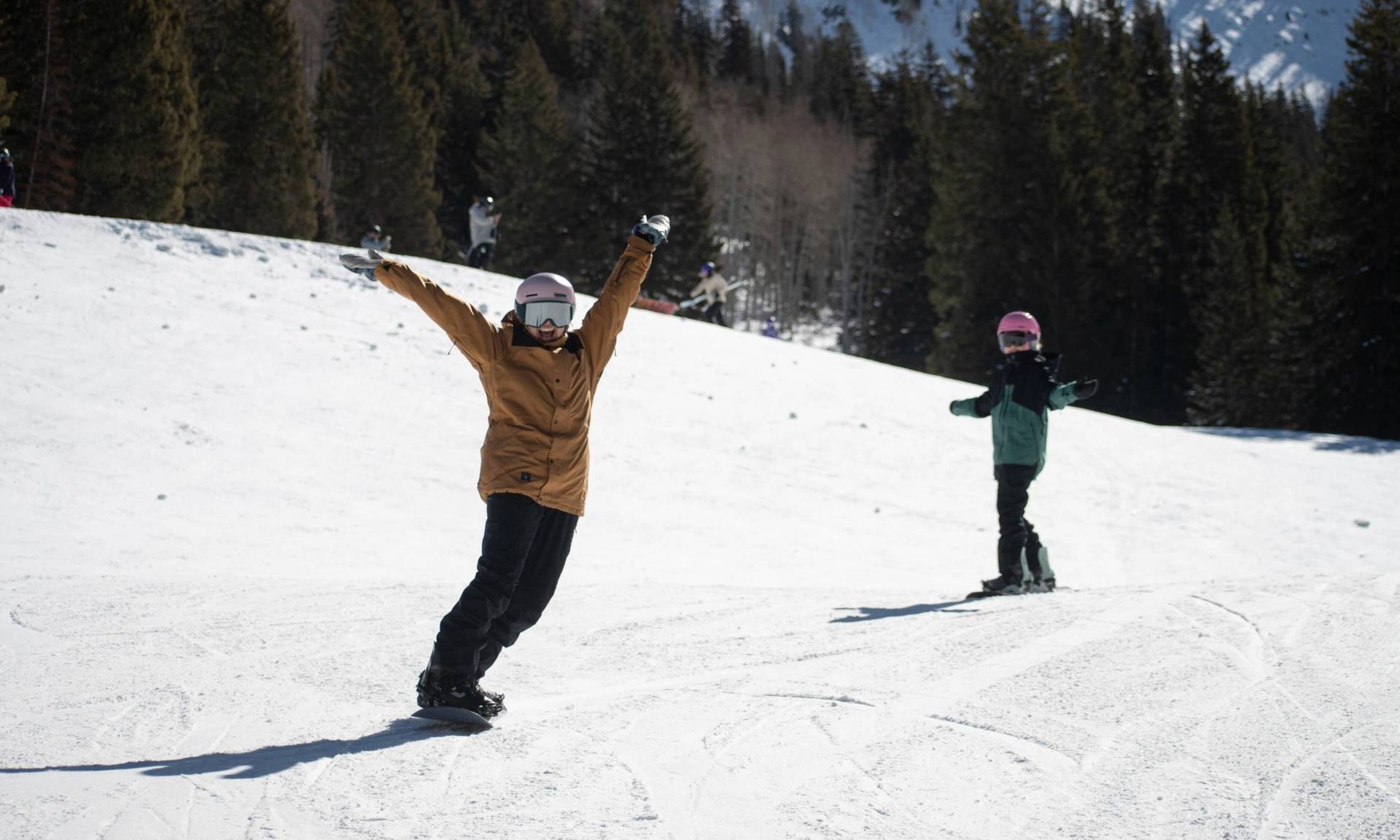 Friends snowboarding together by Snake Creek at Brighton Resort
