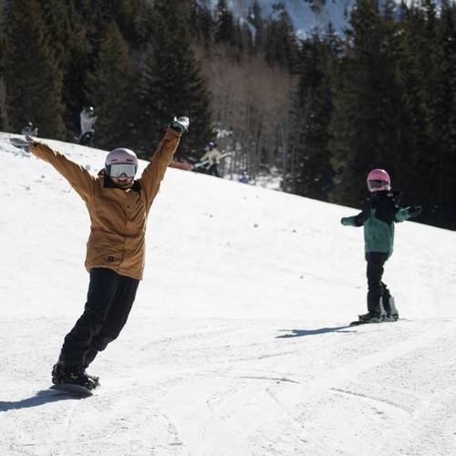 Friends snowboarding together by Snake Creek at Brighton Resort