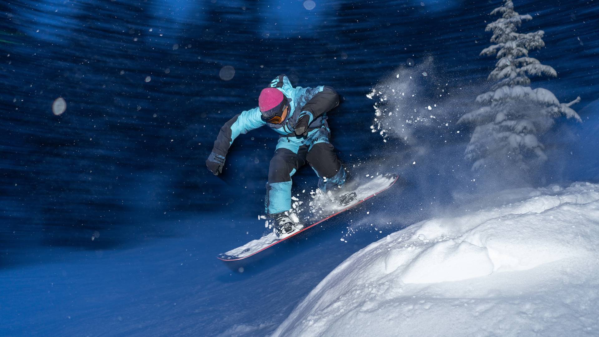 Snowboarder riding powder at night