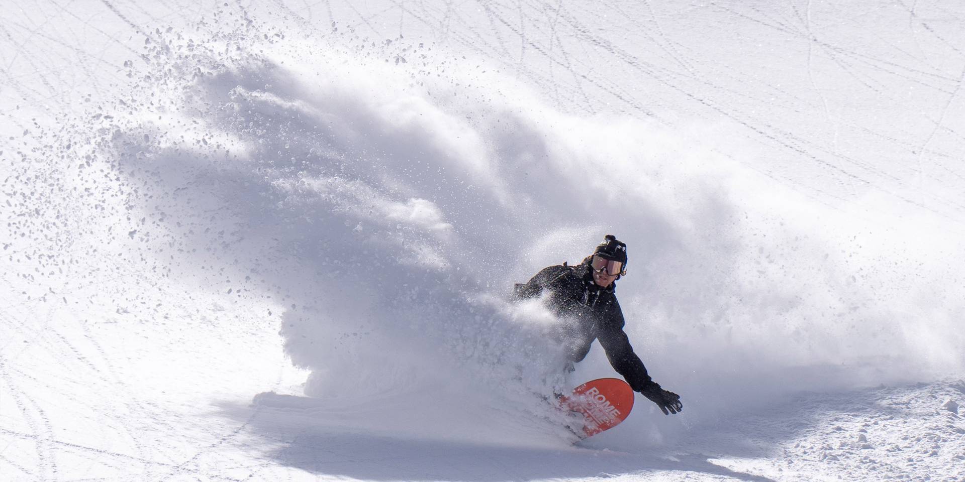 Snowboarde slahing powder