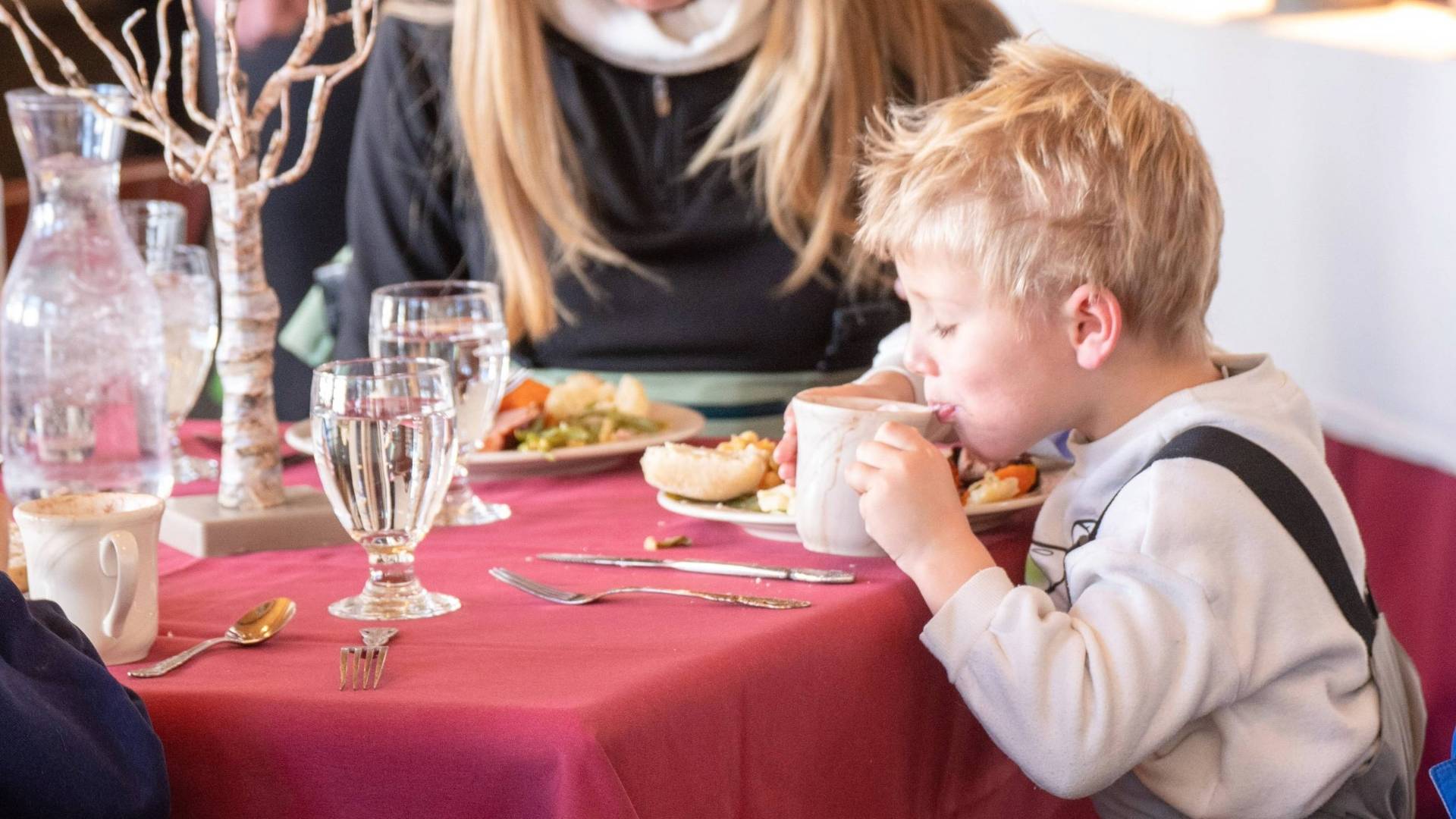 Kid at Thanksgiving dinner with his family at Brighton Resort
