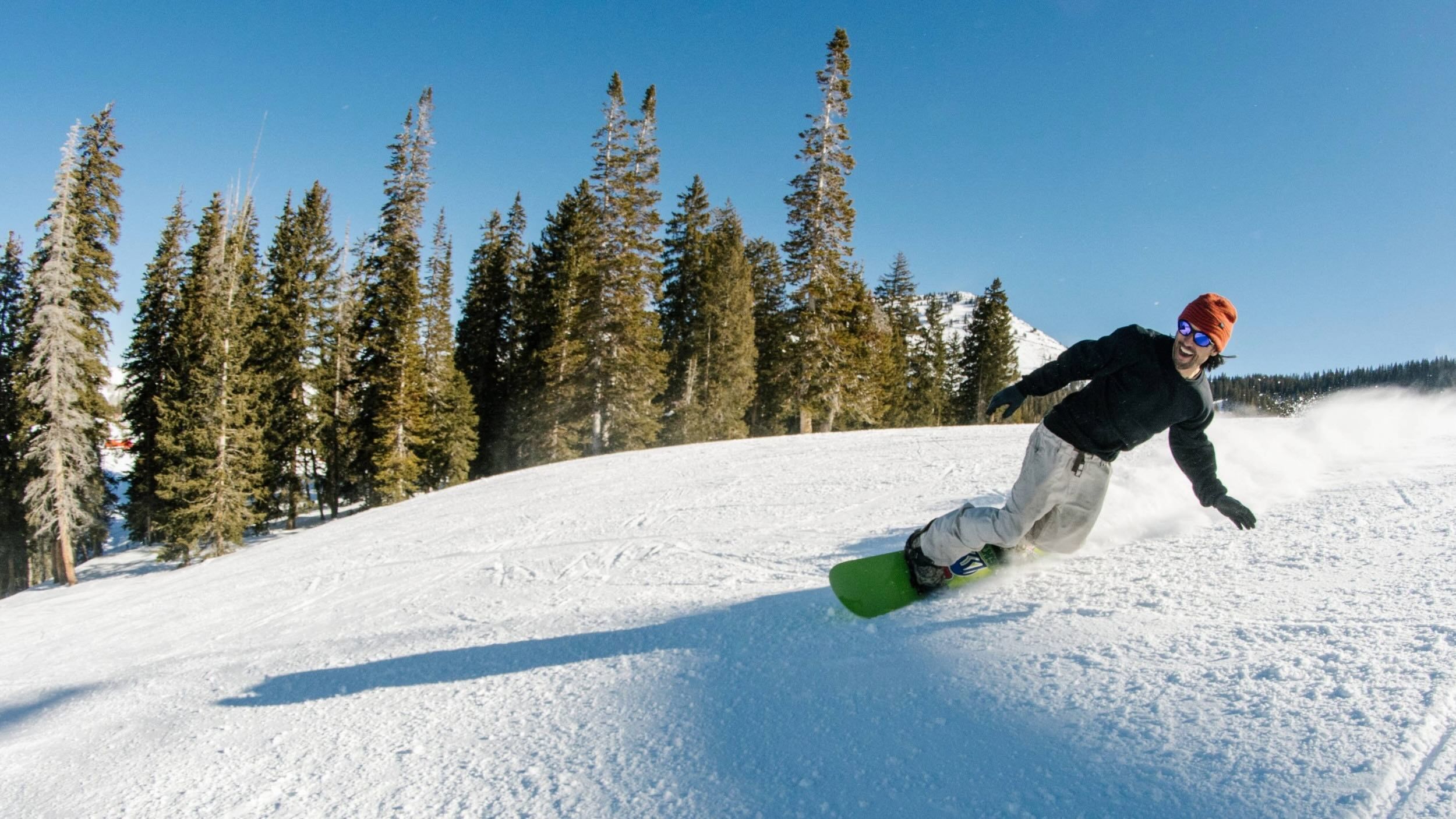 Snowboarder carving on a sunny day at Brighton Resort
