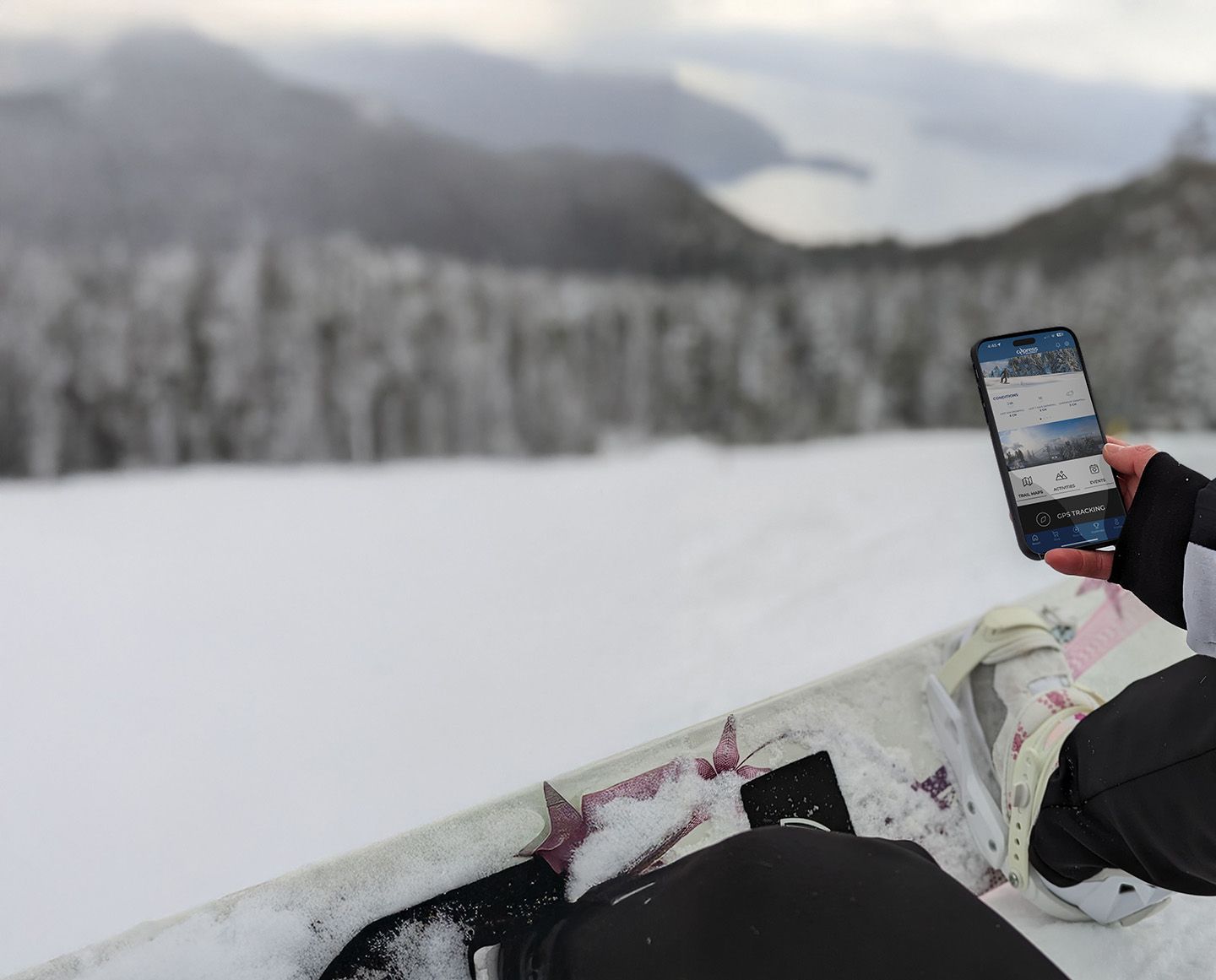 skier checking their phone and browsing the Cypress app on the chairlift.
