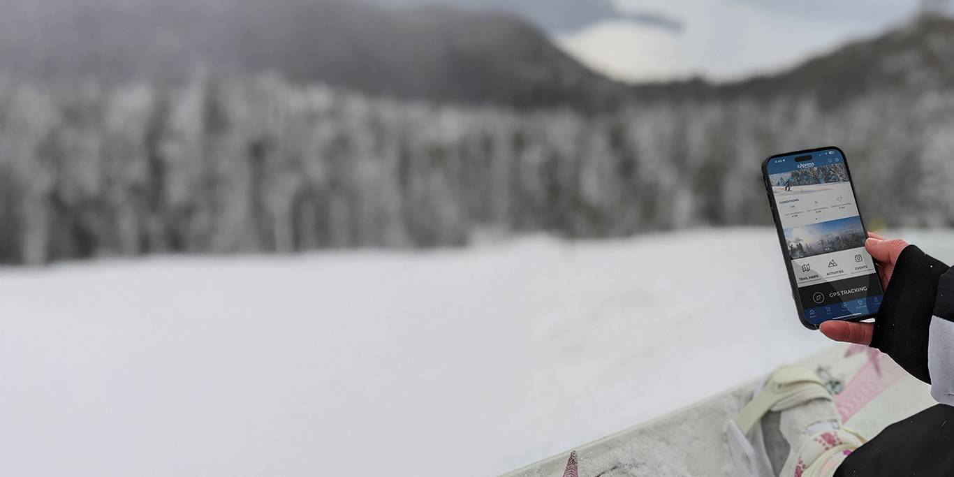 skier checking their phone and browsing the Cypress app on the chairlift.