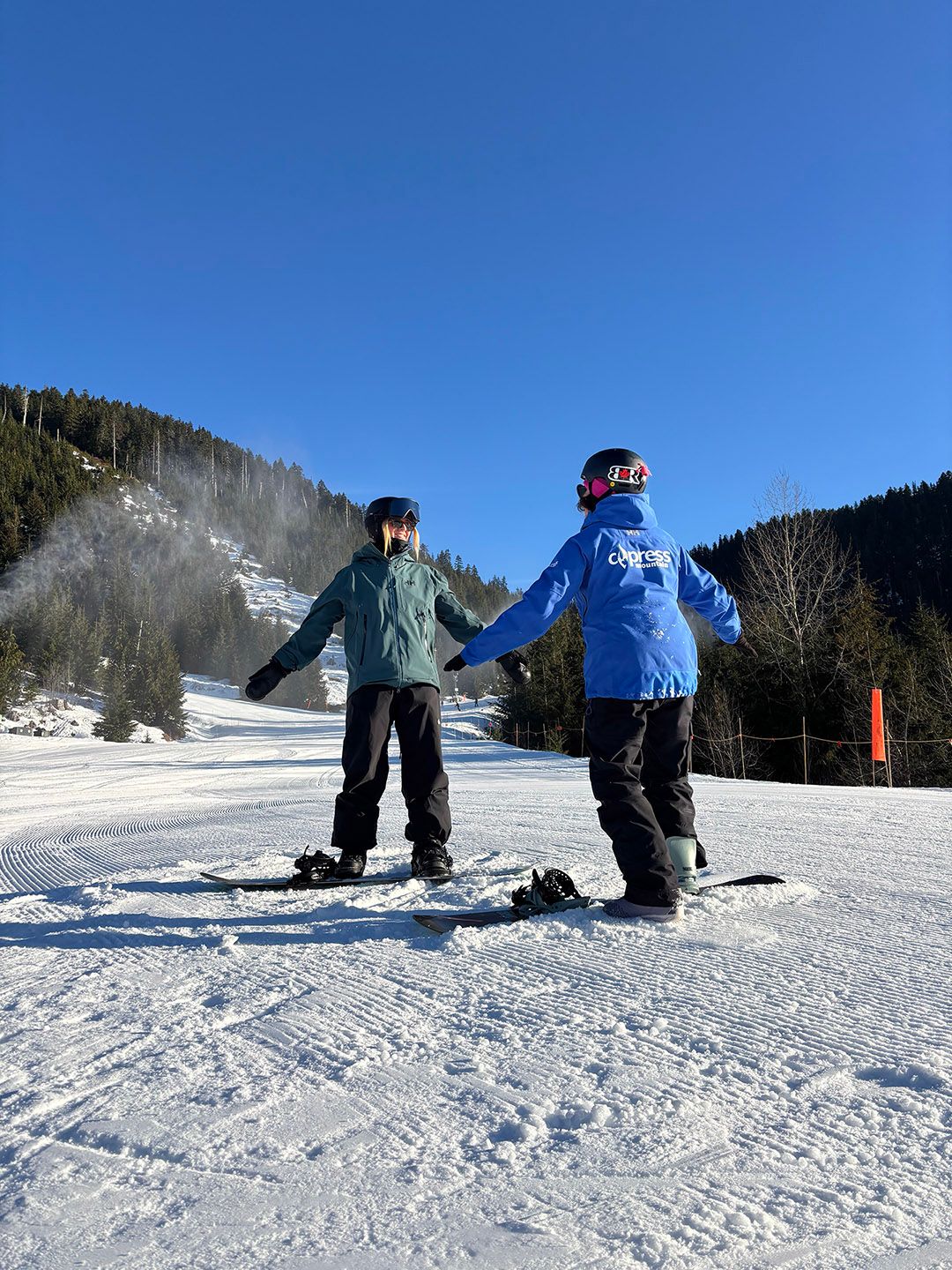 Women skiers and riders in front of a black diamond