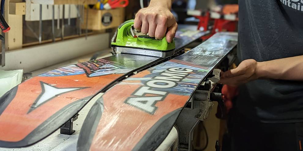 rental employee waxing and tuning Atomic skis.