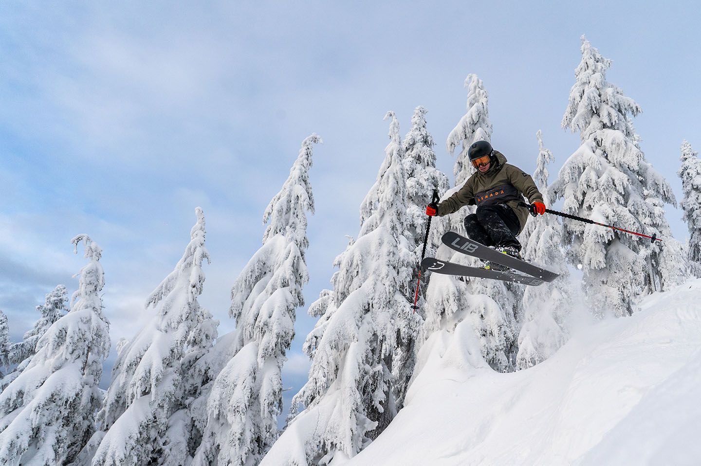 Skier jumping through powder