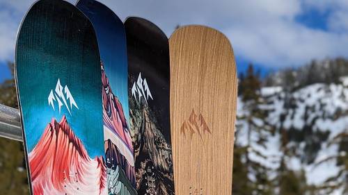 Boards leaning on racks with mountain in the background.