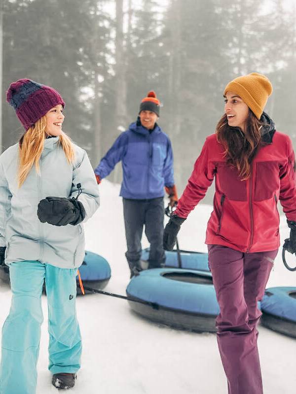 A family carrying their snowtubes.