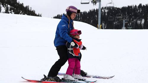 Ski instructor teaching a small kid