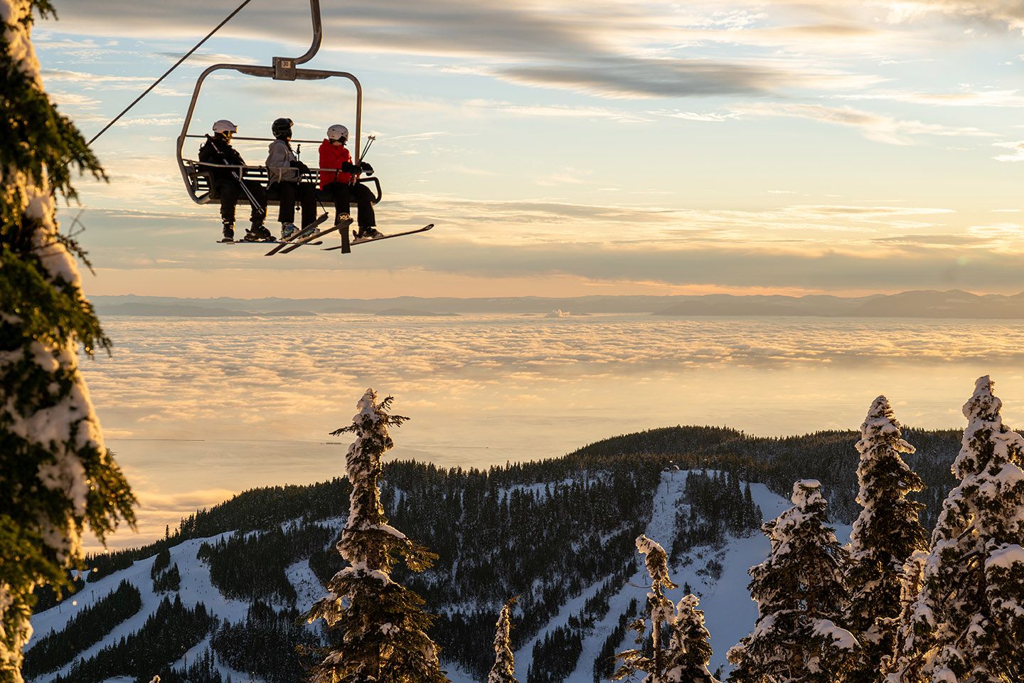 3 skiers looking at sunset views on Sky Chair.