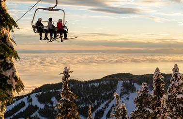 3 skiers looking at sunset views on Sky Chair.