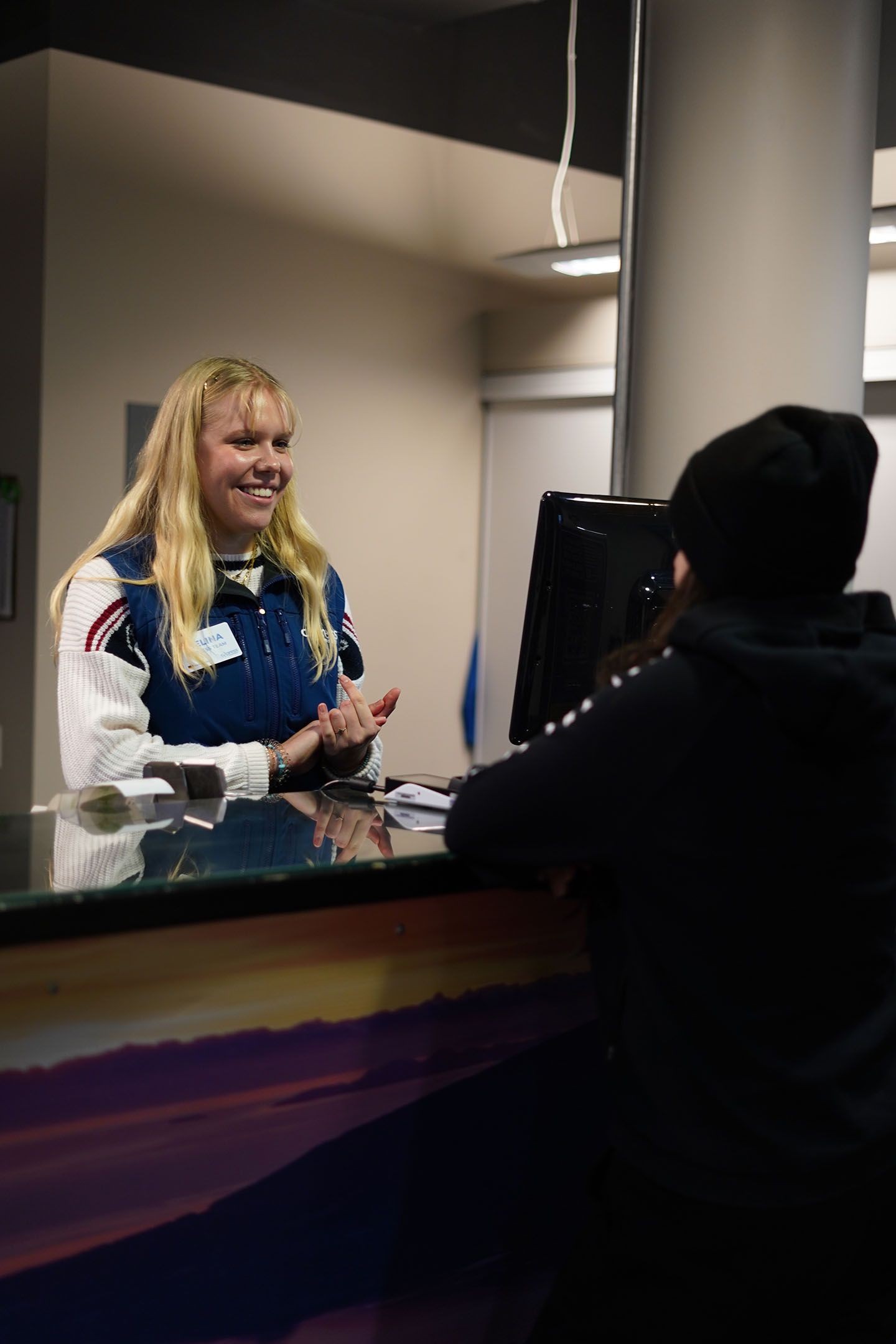 Guest services staff talking to a guest with a smile on her face.