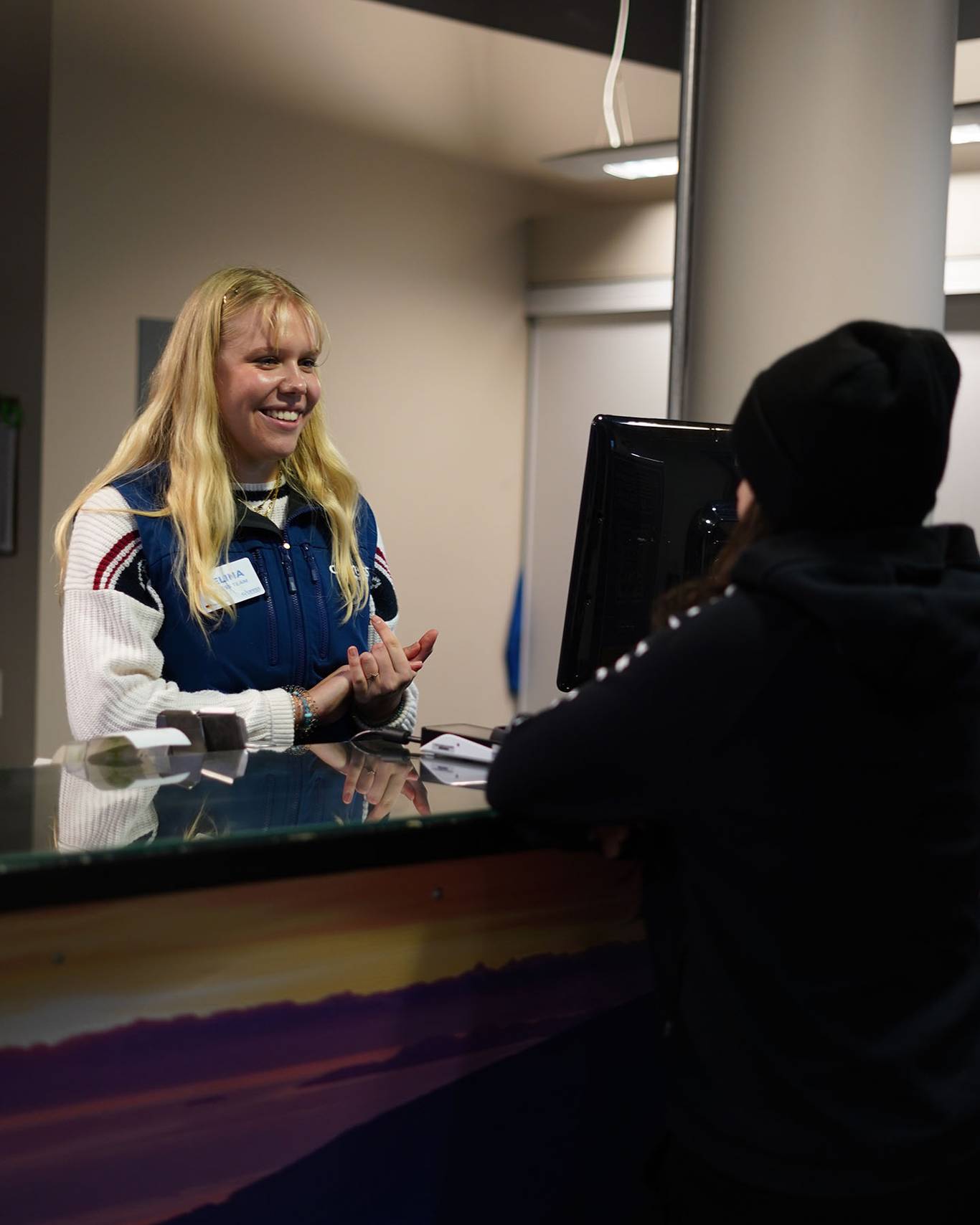 Guest services staff talking to a guest with a smile on her face.