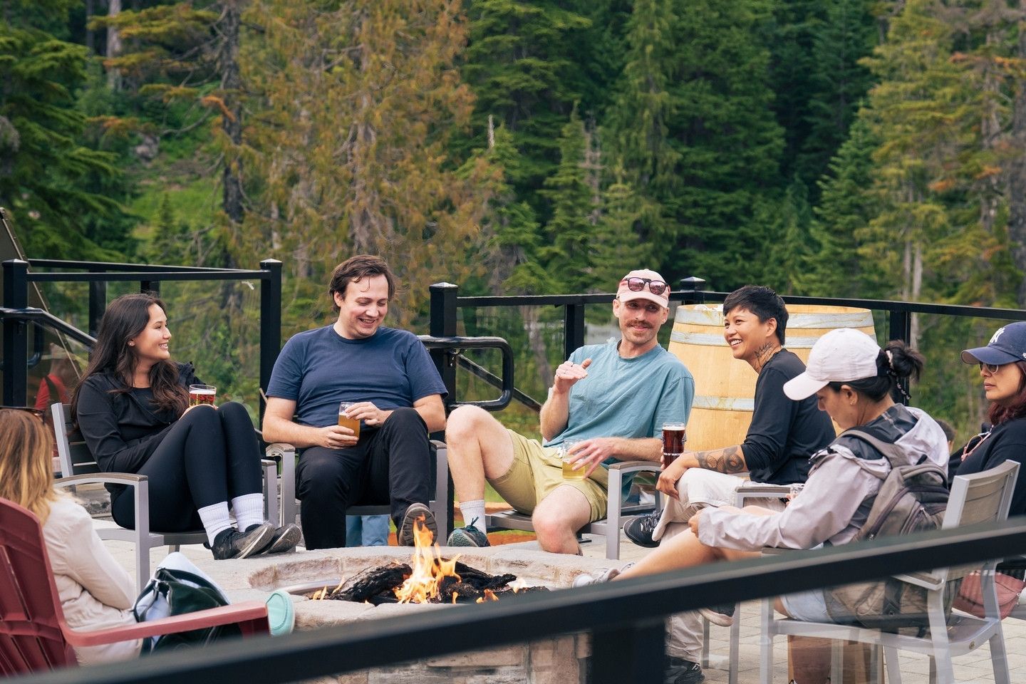 friends sitting by firepit with drinks