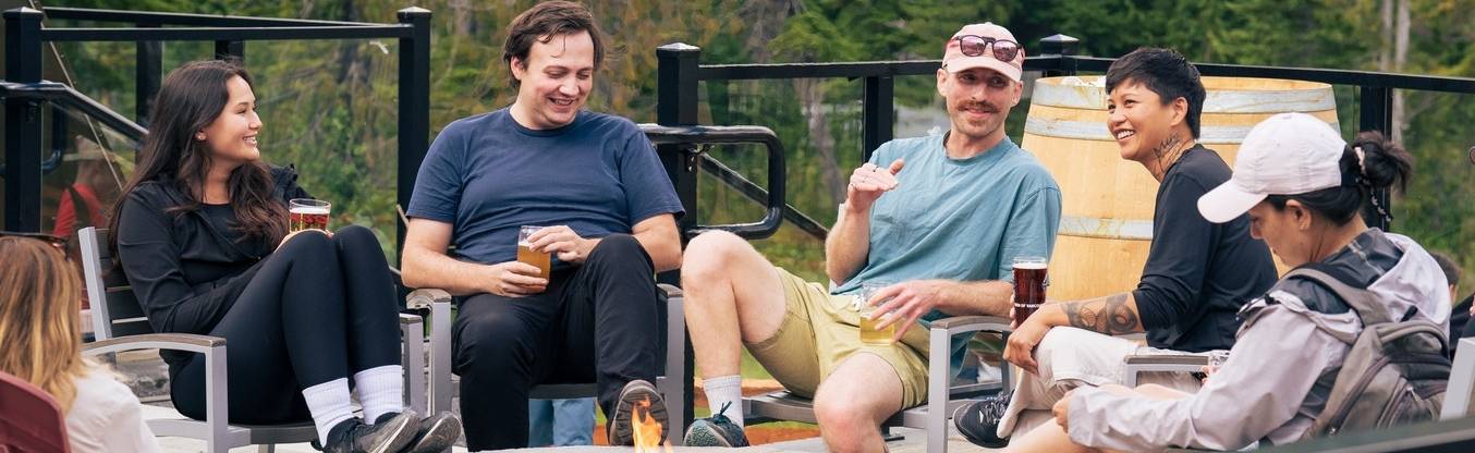 friends sitting by firepit with drinks