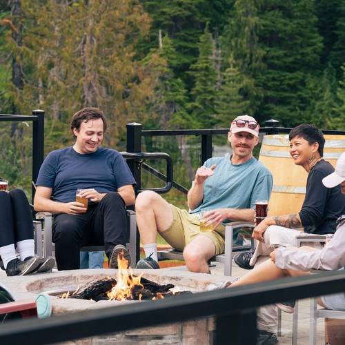 friends sitting by firepit with drinks