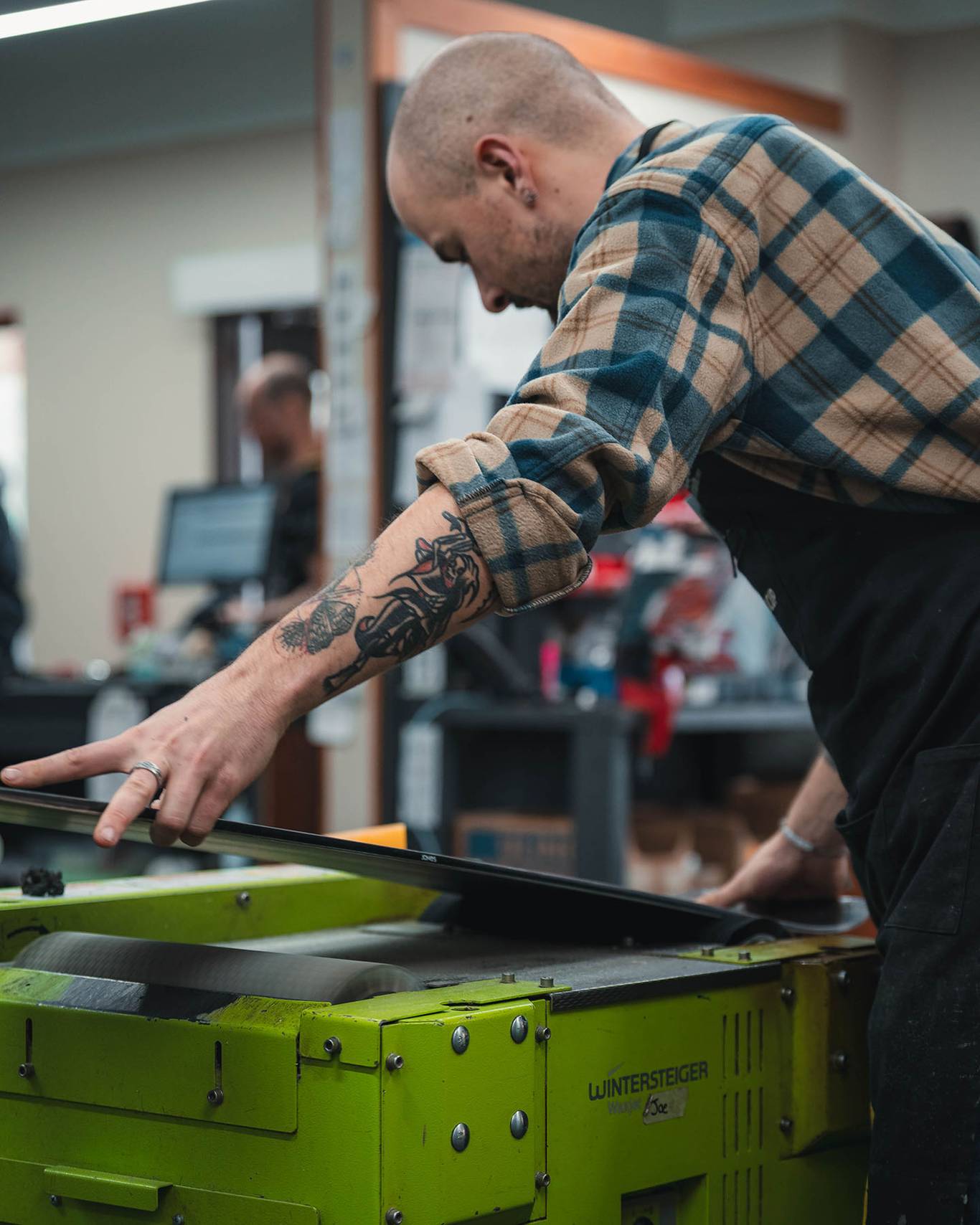 One of the repairs staff waxing a snowboard.