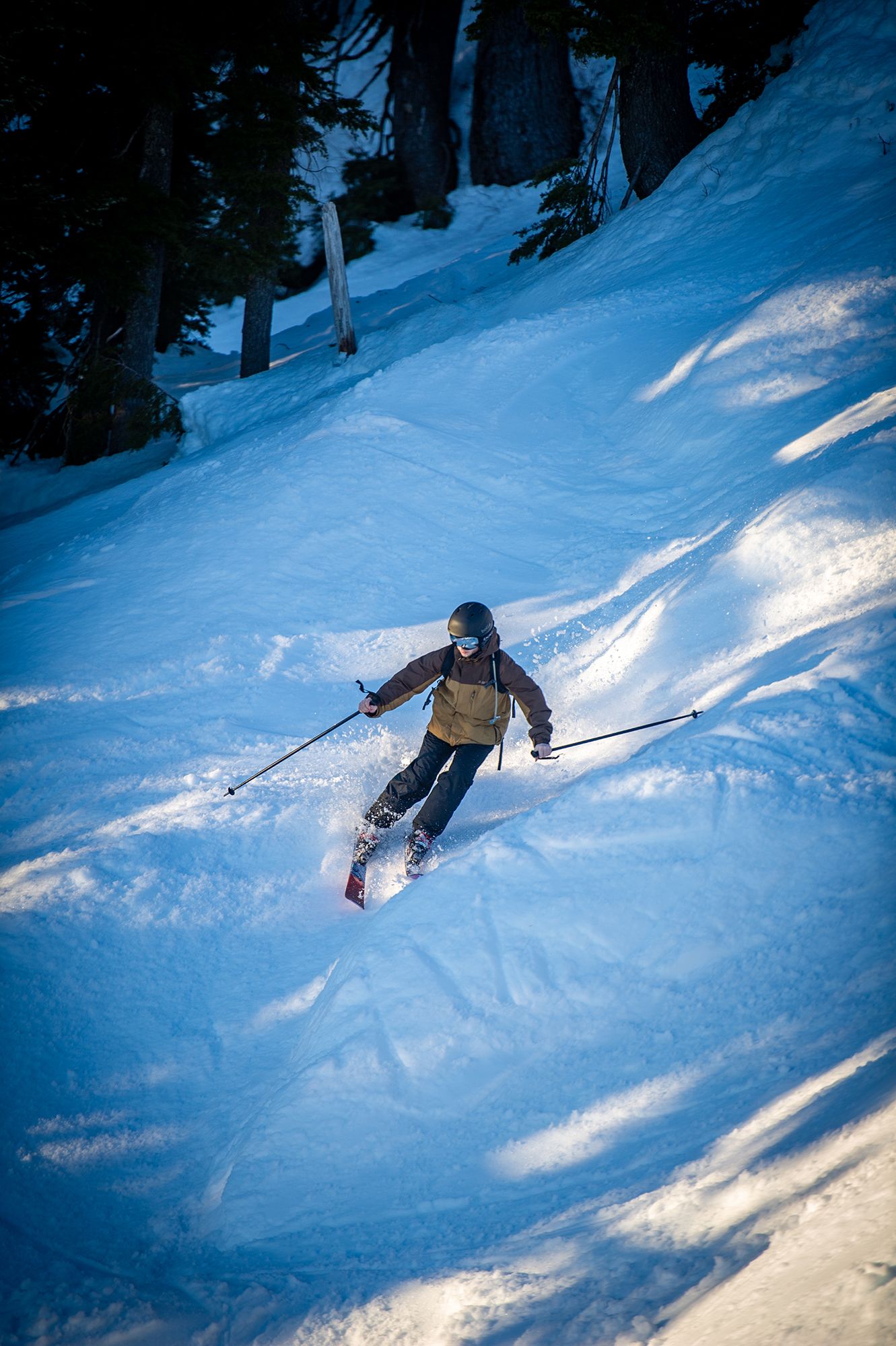 A person skiing downhill on a sunny day.