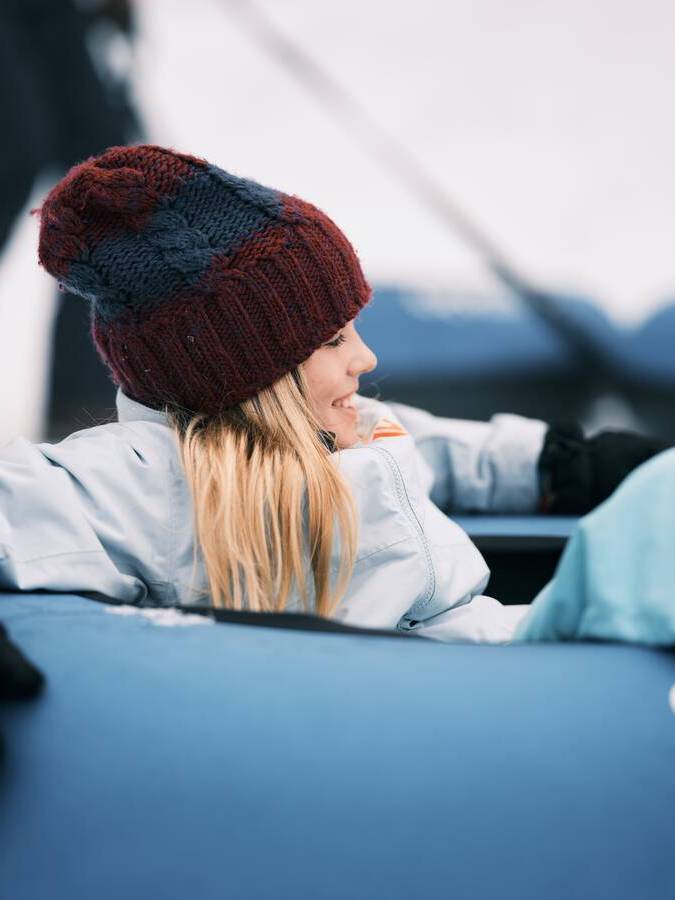 A girl sits in a blue snow tube.