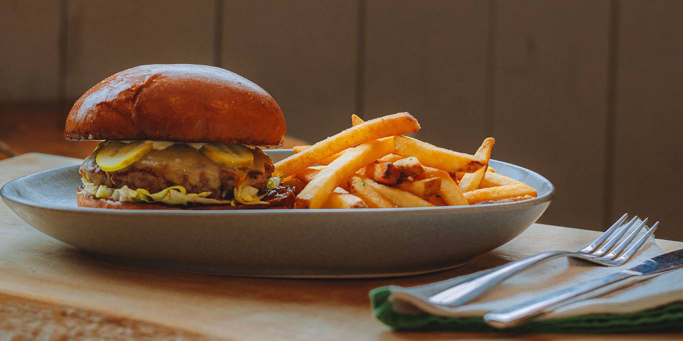 cheese burger with pickle lettuce and coleslaw served with fries at Hollyburn Lodge