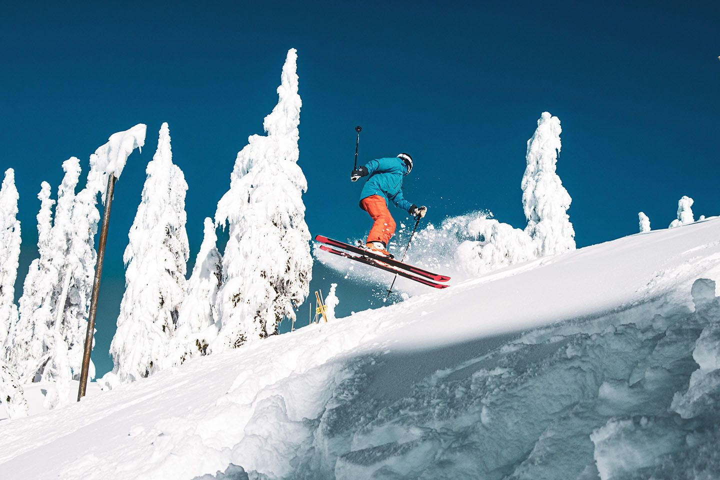 Skier performing a spin jump on a bluebird day.