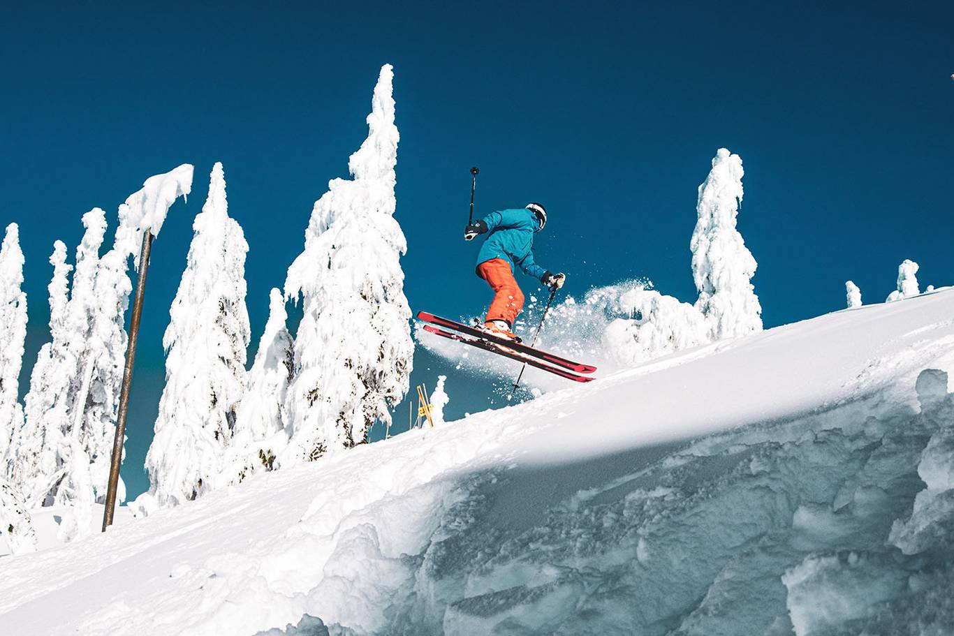 Skier performing a 360 jump from powdery snow.