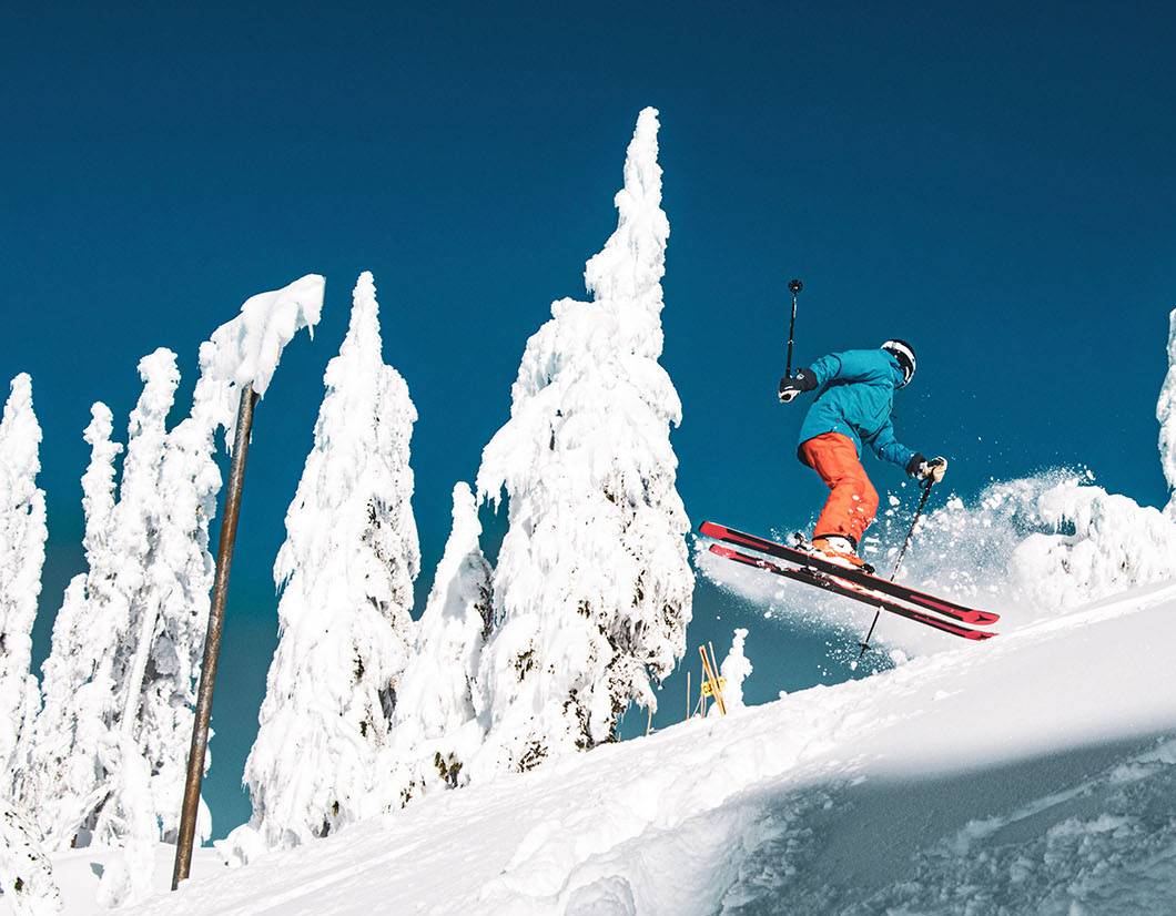 Skier performing a spin jump on a bluebird day.