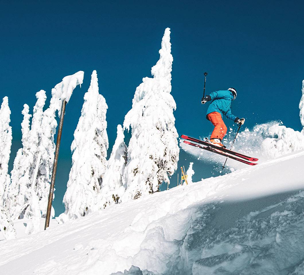 Skier performing a spin jump on a bluebird day.