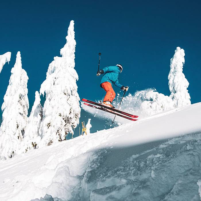 Skier performing a 360 jump on a bluebird day.